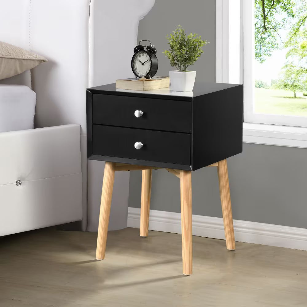 Shopi Vella black mid-century modern bedside table with two drawers and wooden legs next to a white bed