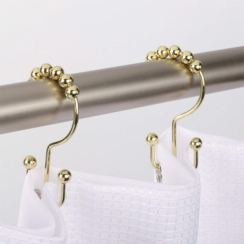 Shopi Vella mountain shaped ball curtain hook in gold holding white bathroom shower curtain on silver rod