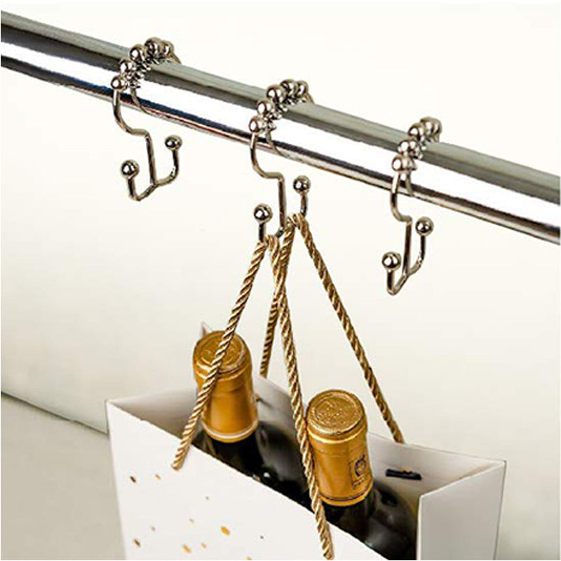 Silver mountain shaped ball curtain hook hanging on rod holding a shopping bag with bottles