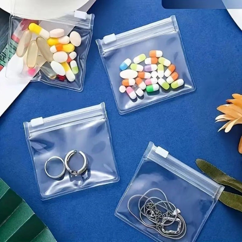 Shopi Vella clear split bag drug organizer for travel holding pills and jewelry on blue surface
