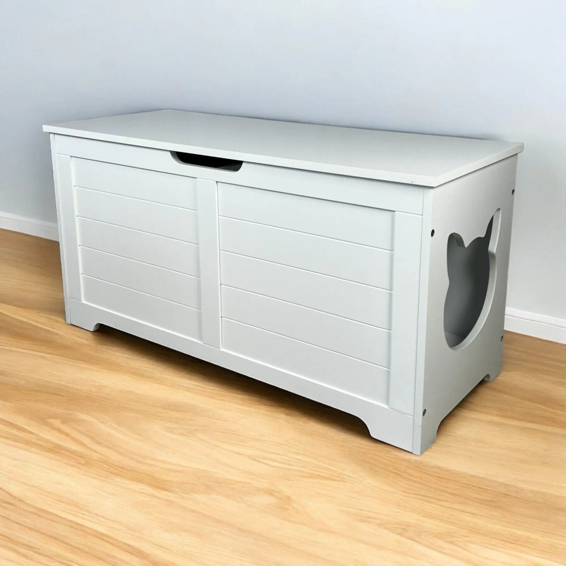 White wooden top open litter box furniture with side cat-shaped entrance on hardwood floor