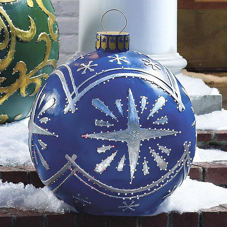 Shopi Vella giant outdoor Christmas ornament ball in blue with silver star design sitting on snowy steps