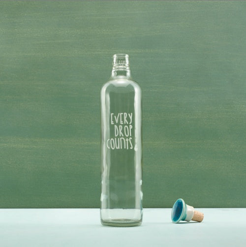Shopi Vella glass water bottle with ceramic stopper featuring Every Drop Counts text