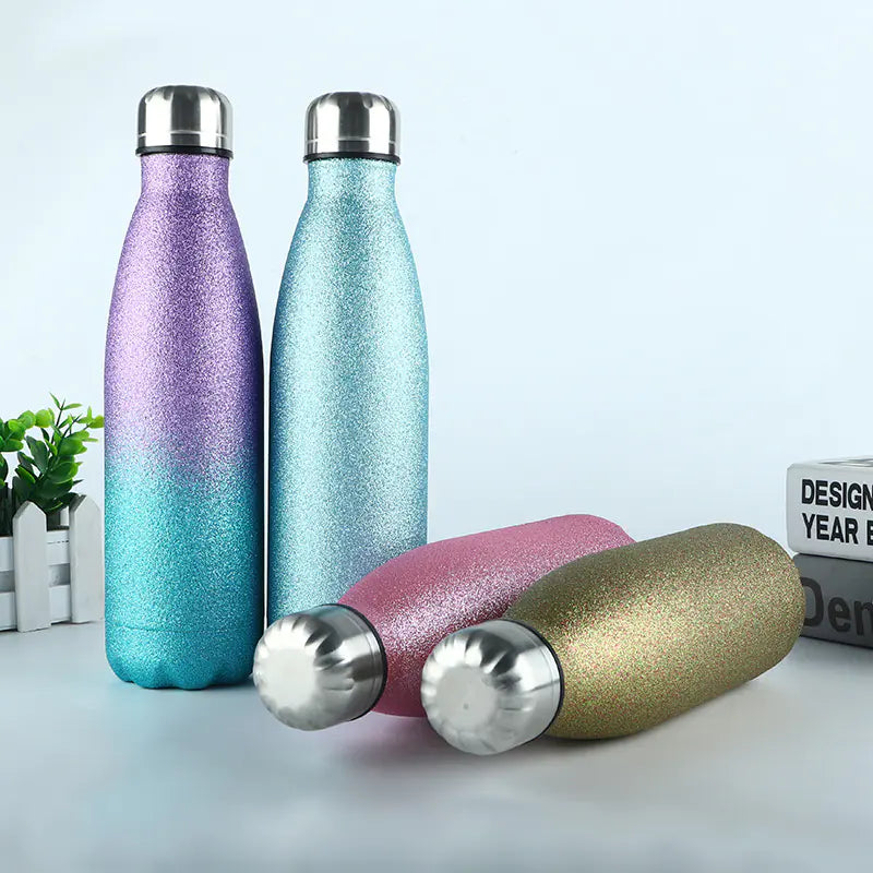 Set of four colorful durable metal sports bottles for hydration with metallic caps on a white surface