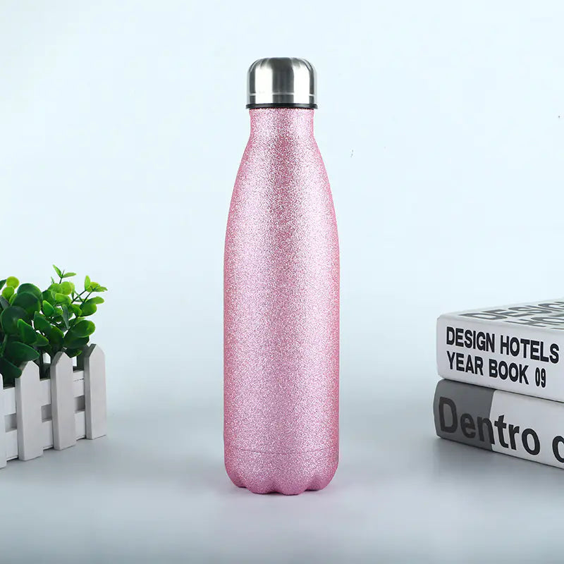 Pink glitter durable metal sports bottle for hydration with a stainless steel cap on a white surface