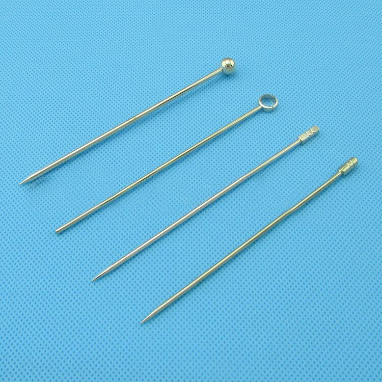 Set of gold fancy cocktail picks for parties with unique decorative tops on a blue background