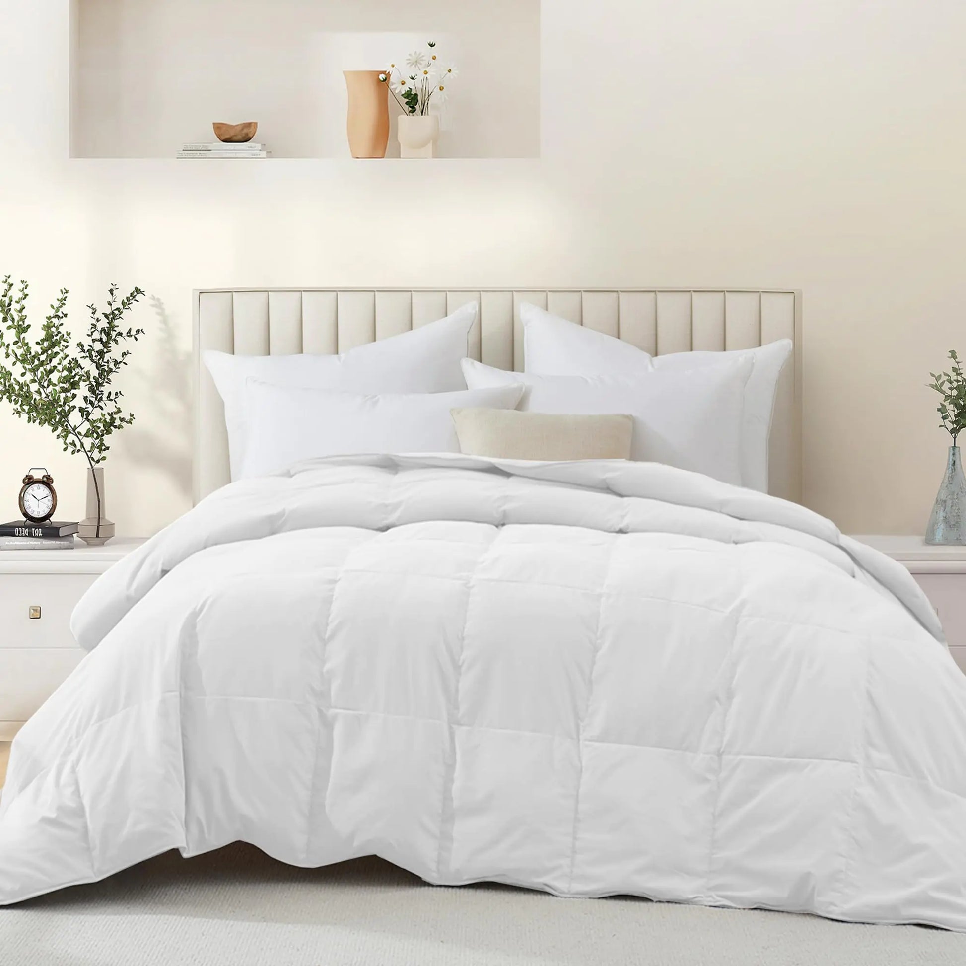 White goose feather down comforter neatly spread on bed with white pillows in modern bedroom