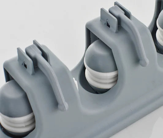 Close-up of gray wall-mounted mop and broom holder with rubber grips for secure tool storage
