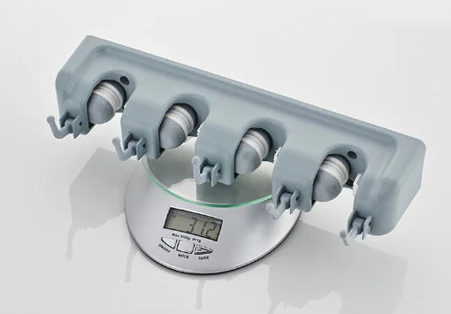 Gray wall-mounted mop and broom holder with four adjustable grips placed on a digital scale