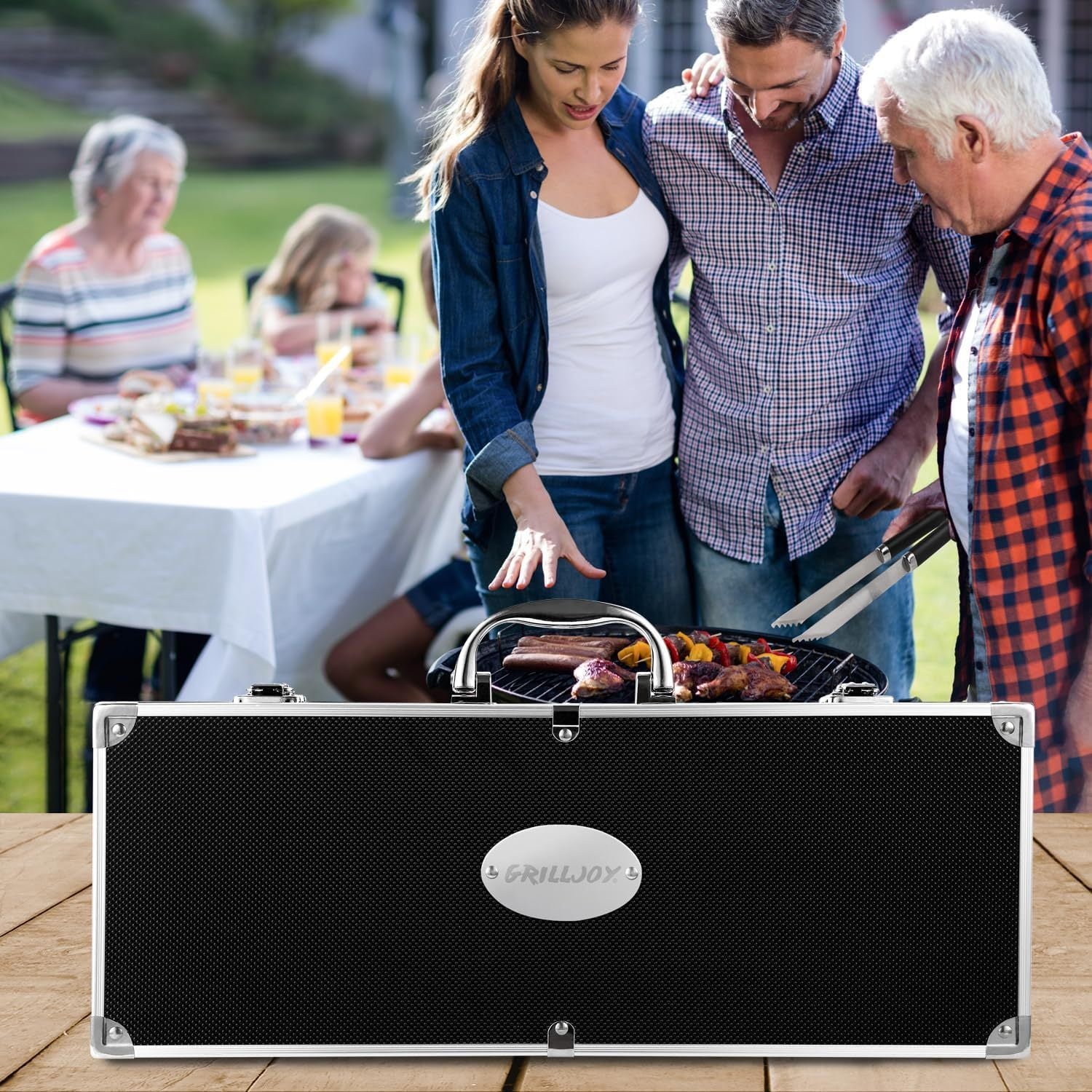 BBQ grill tools set stainless steel in a black carrying case on wooden table with people grilling in background