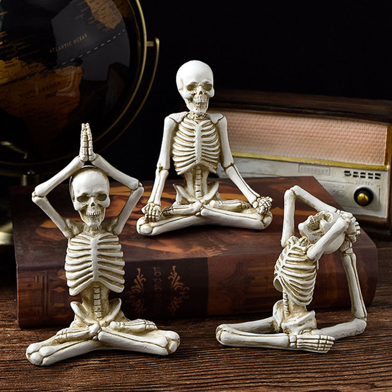 Halloween yoga skeleton decor set with three detailed skeletons in different yoga poses on a wooden surface