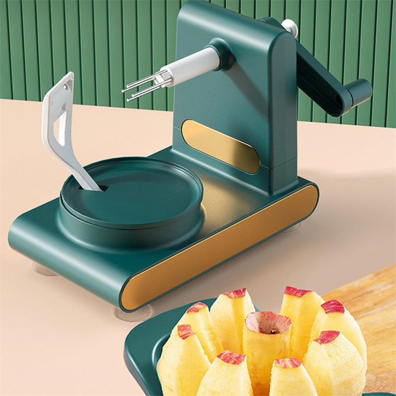 Shopi Vella hand-cranked fruit peeler machine in green and gold peeling an apple with kitchen storage base