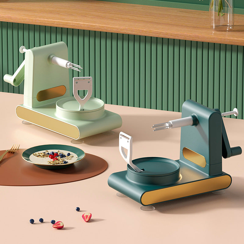 Shopi Vella hand-cranked fruit peeler machine in green and beige kitchen storage setup with sliced fruit and breakfast bowl