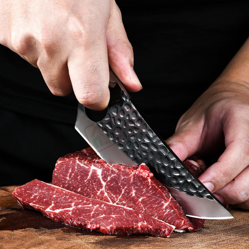 Shopi Vella hand forged boning knife slicing raw marbled beef on a wooden cutting board