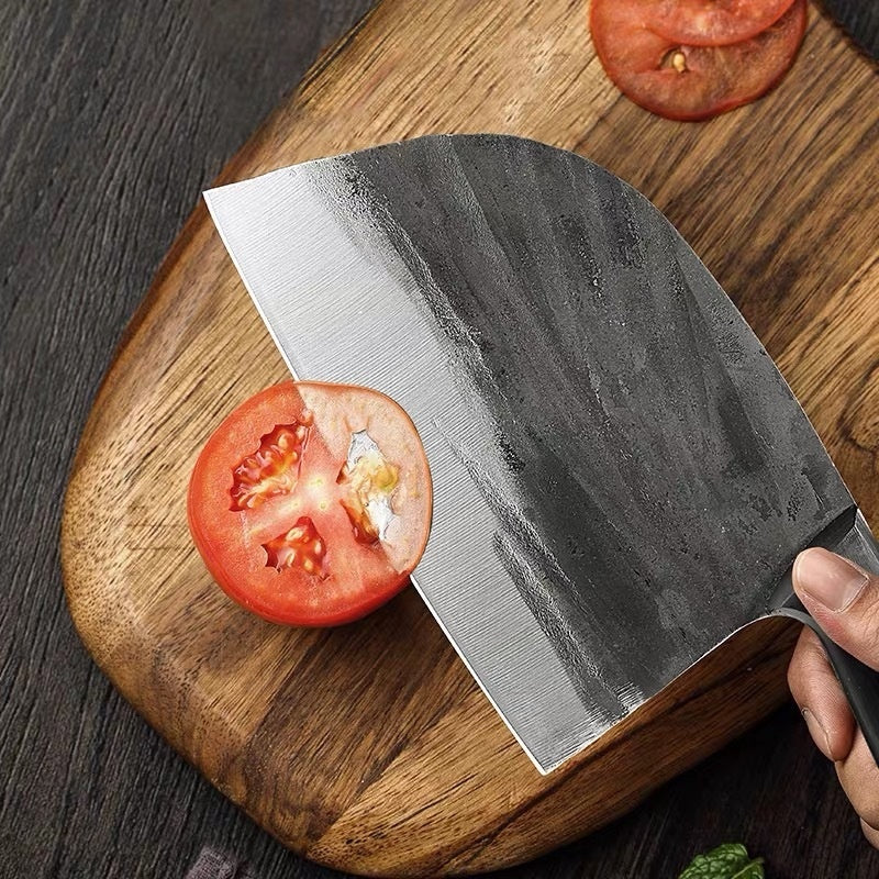 Shopi Vella hand-forged kitchen slicing knife cutting a tomato on wooden cutting board