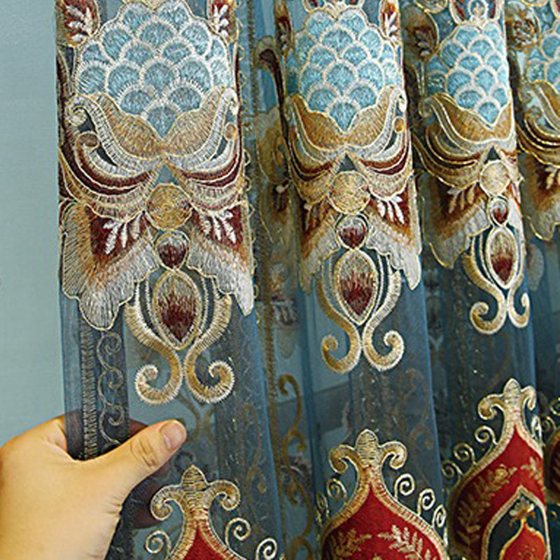 Close-up of modern velvet living room curtains with intricate embroidered floral patterns and a sheer design