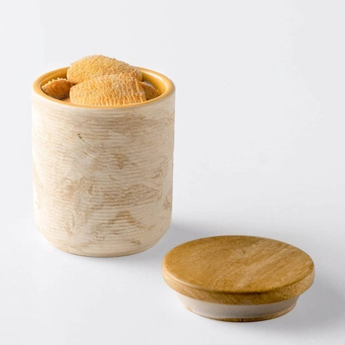 Shopi Vella handcrafted ceramic jar with wooden lid holding honeycomb pieces on white background