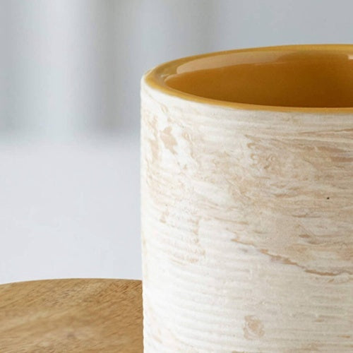 Shopi Vella handcrafted ceramic jar with textured beige exterior and glossy mustard interior