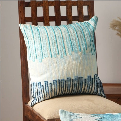 Shopi Vella handcrafted coastal pillow case with blue and white textured vertical stripes on wooden chair