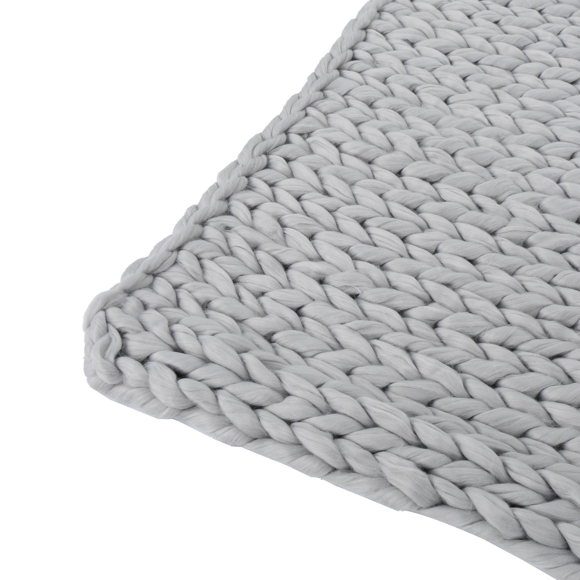 Close-up of a light gray handwoven thick yarn blanket showcasing chunky knit texture