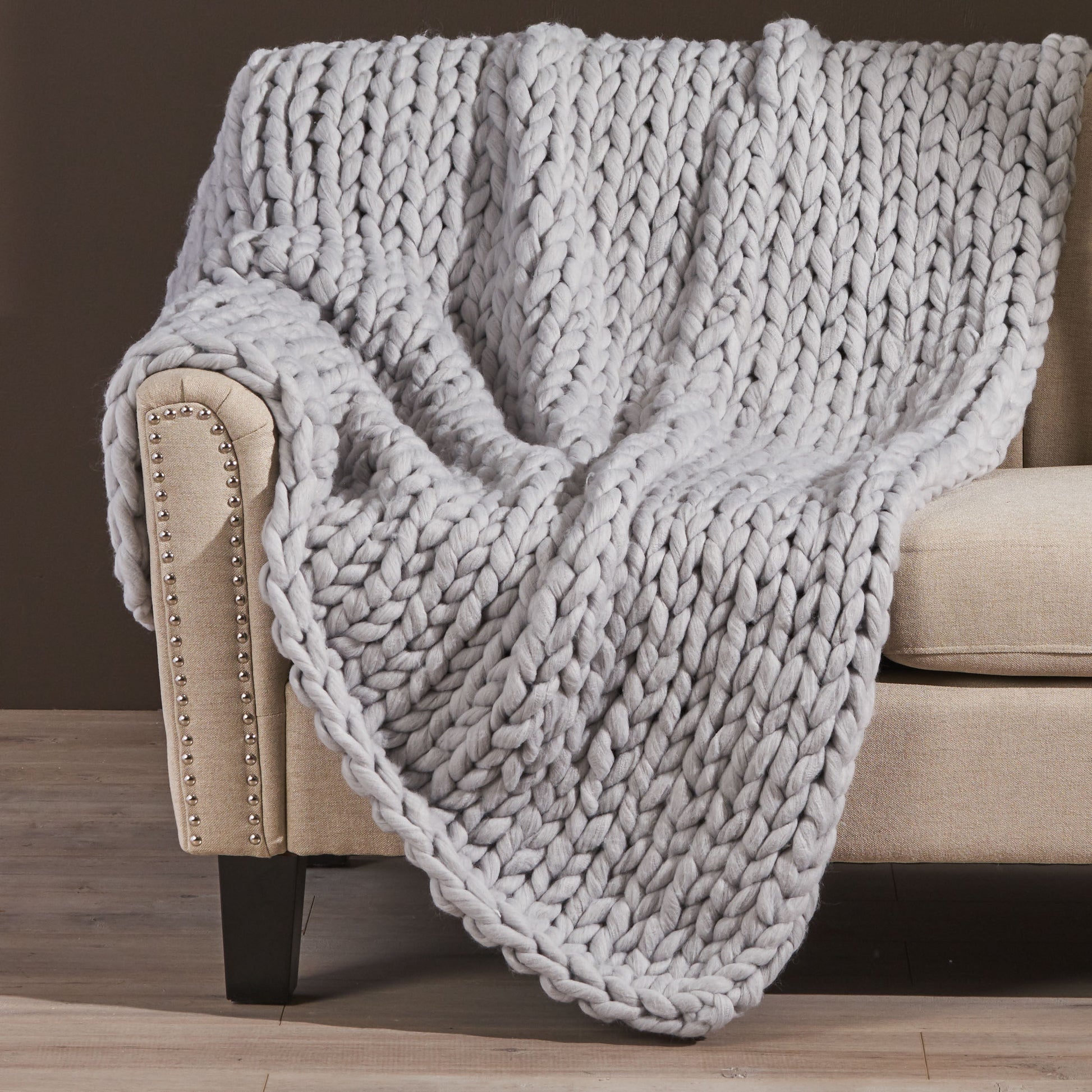 Shopi Vella handwoven thick yarn blanket draped over beige sofa armrest
