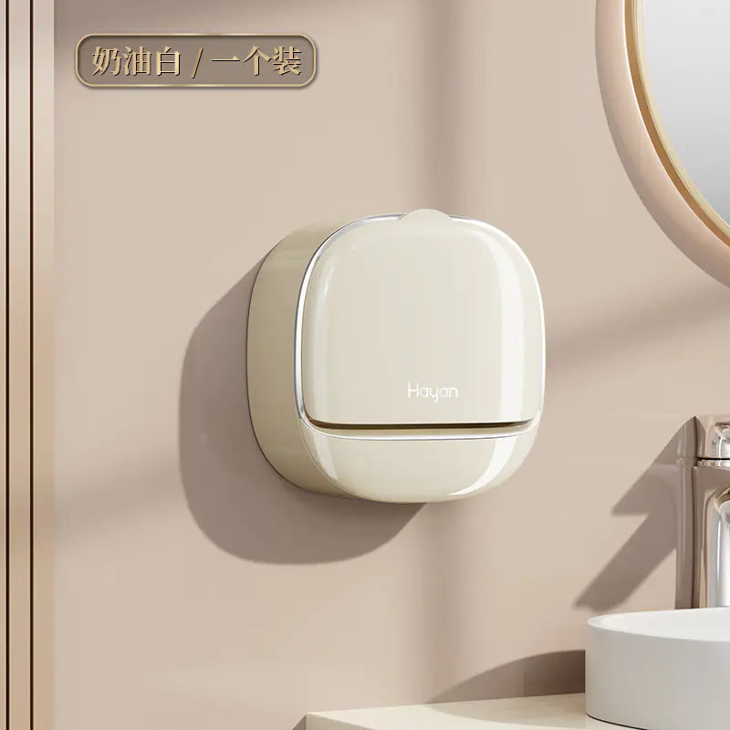 Cream-colored wall mounted soap dish installed on a beige bathroom wall near a round mirror
