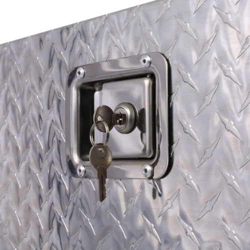 Close-up of lock and key on a heavy duty truck bed storage box with diamond plate texture