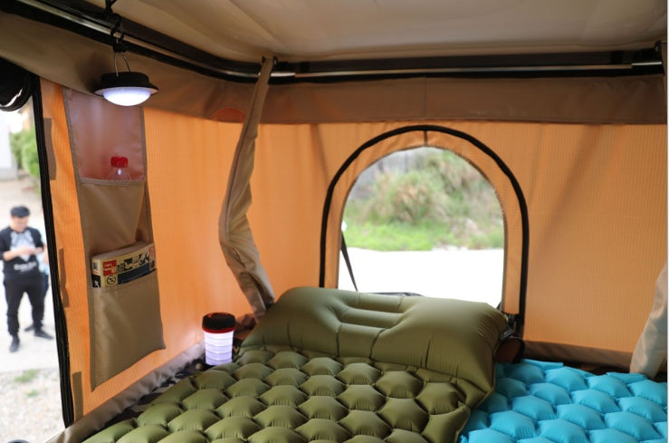 Shopi Vella inflatable camping mattress inside a tent with headrest and soft lighting