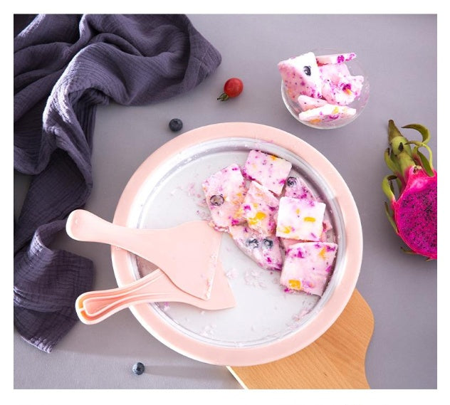 Homemade rolled ice cream machine pan with pink scrapers and mixed fruit ice cream rolls