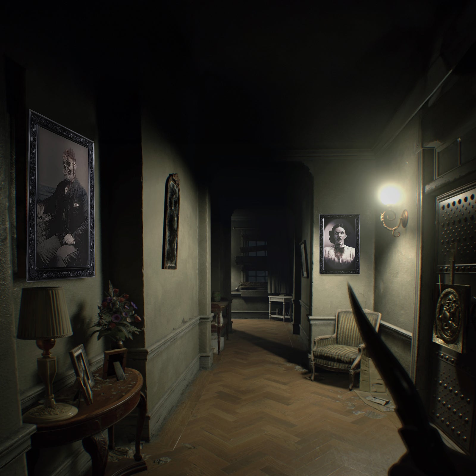 Dark creepy hallway with horror party decorations for home including eerie portraits and dim lighting