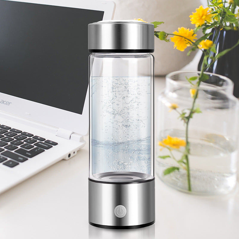 Shopi Vella hydrogen water bottle portable with sleek silver design on a desk next to a laptop