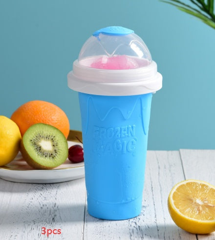 Shopi Vella instant frozen drink cup in blue with clear dome lid surrounded by fresh fruits