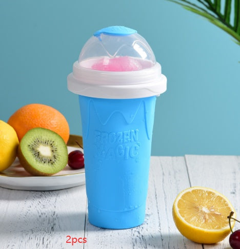 Shopi Vella instant frozen drink cup in blue with dome lid and fruit background on white wooden table