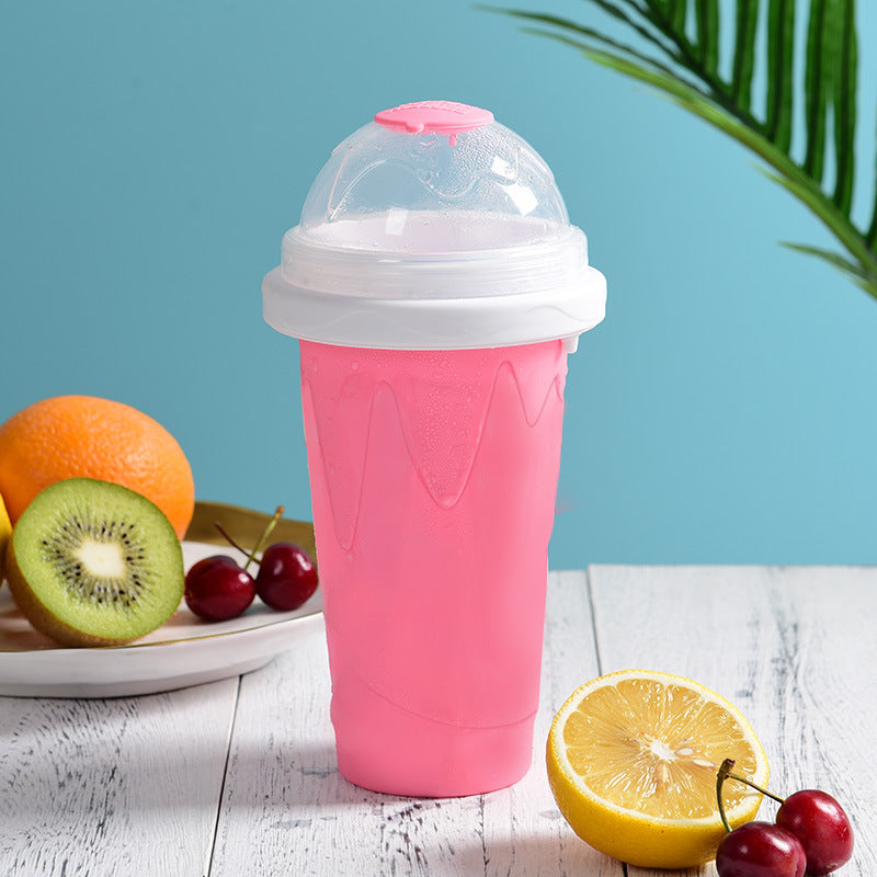 Shopi Vella pink instant frozen drink cup with clear dome lid on white wooden table with fruit