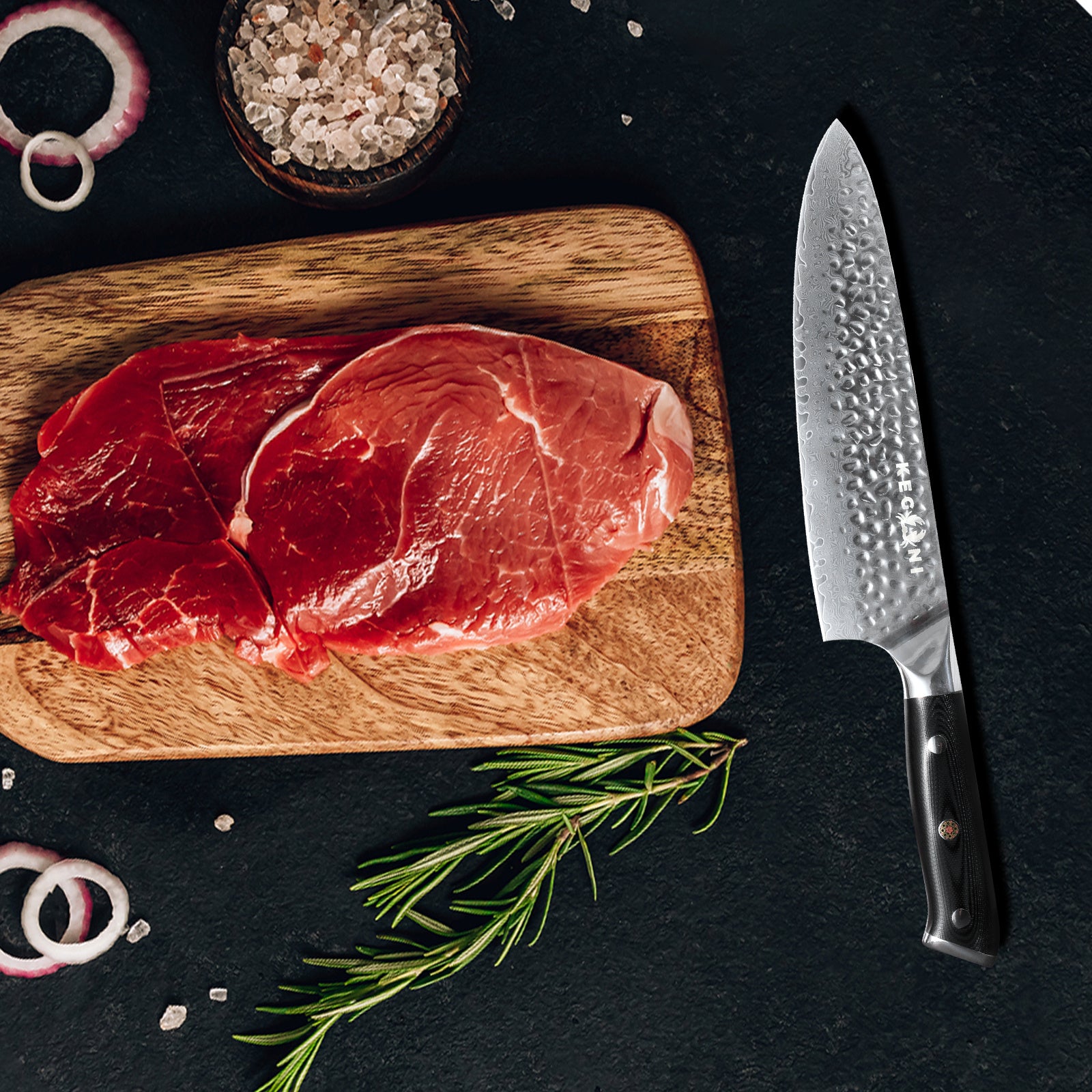 Damascus chef knife 8 inch with hammered blade and black handle next to raw steak on wooden cutting board