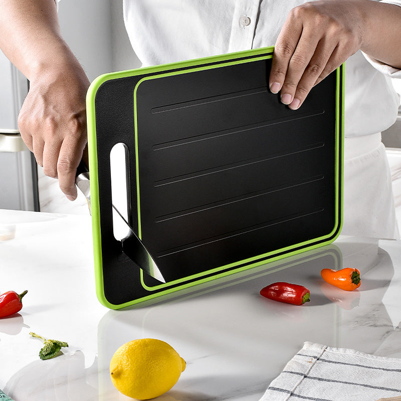 Shopi Vella kitchen chopping board with knife sharpener in black and green held by person over white countertop