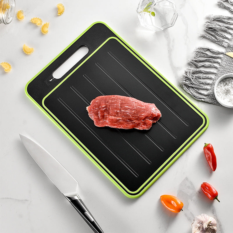Shopi Vella kitchen chopping board with knife sharpener featuring a black surface with green edges and a piece of raw meat on top