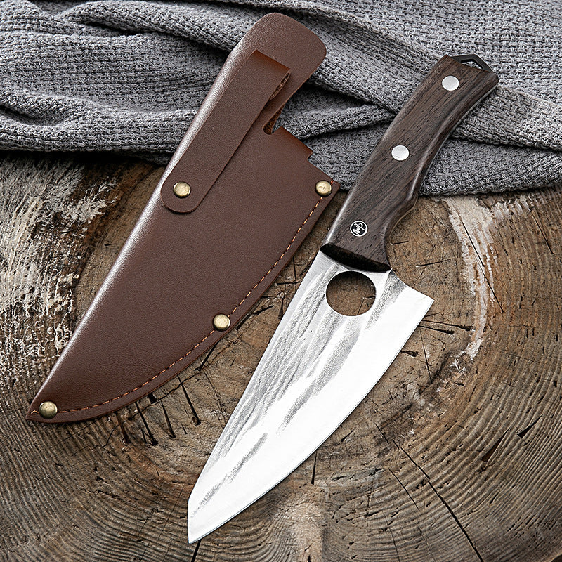 Shopi Vella kitchen deboning knife with wooden handle and brown leather sheath on wooden surface