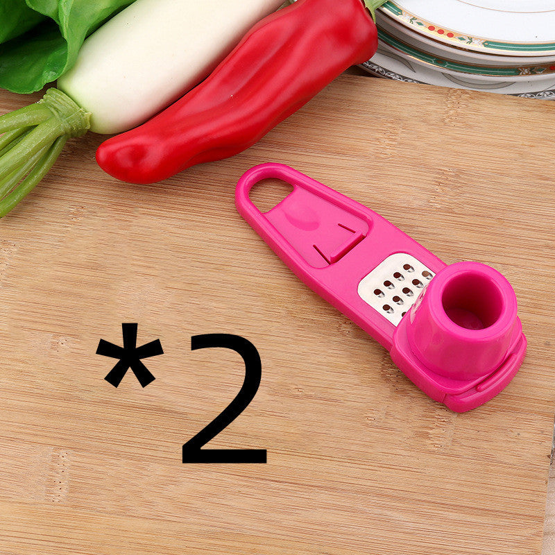 Shopi Vella pink garlic masher kitchen tool with grater and ergonomic handle on wooden cutting board