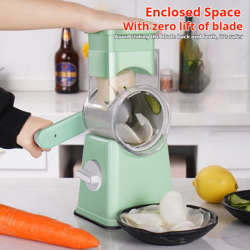 Shopi Vella kitchen vegetable slicer in green with hand crank slicing white vegetables over black bowl