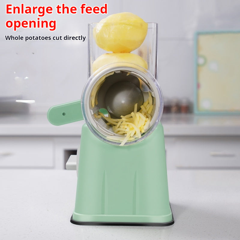 Shopi Vella kitchen vegetable slicer in green slicing whole peeled potatoes on white countertop