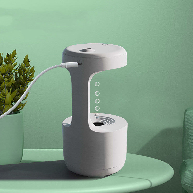 Shopi Vella large capacity aroma diffuser in white on green table with plant in background