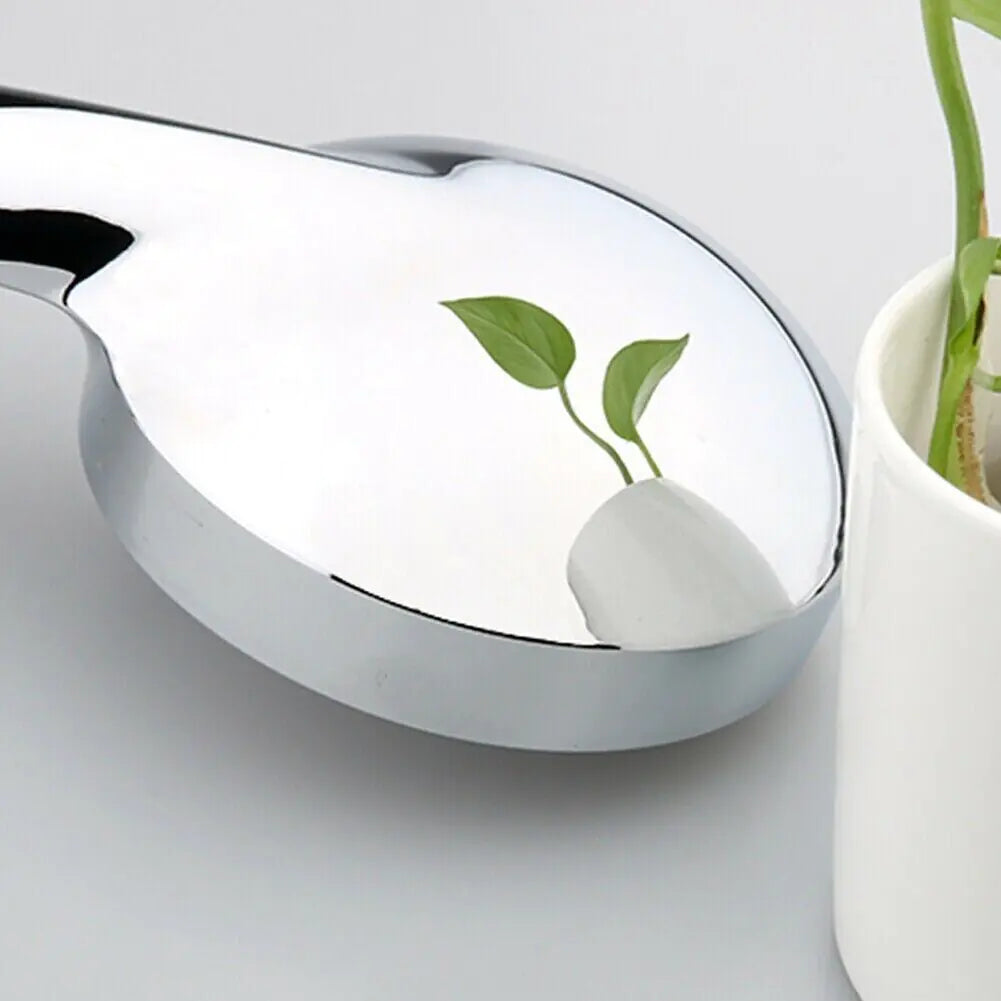 Close-up of shiny chrome LED color changing shower head reflecting green plant leaves
