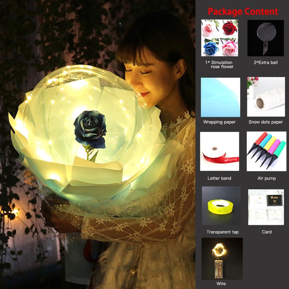 Woman holding an illuminated LED rose balloon bouquet with a blue rose inside glowing white petals