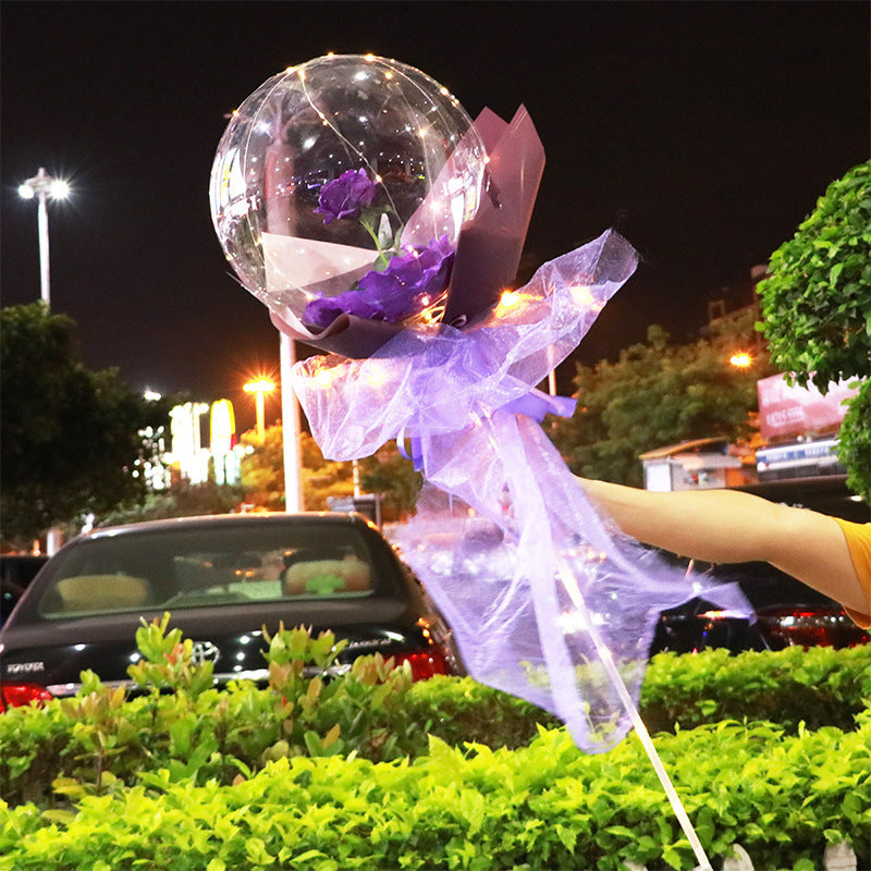 Shopi Vella LED rose balloon bouquet with purple wrap and fairy lights held outdoors at night