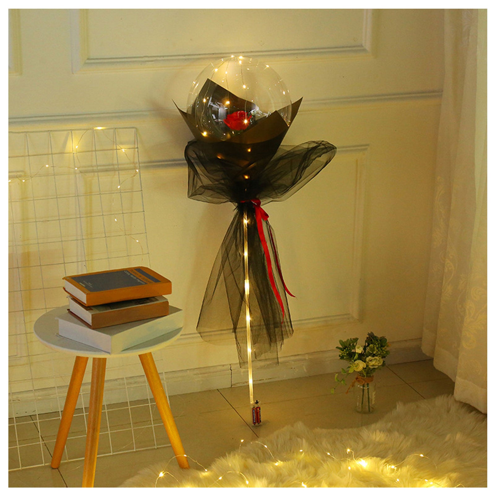 Shopi Vella LED rose balloon bouquet with black and red wrapping and string lights in cozy room decor