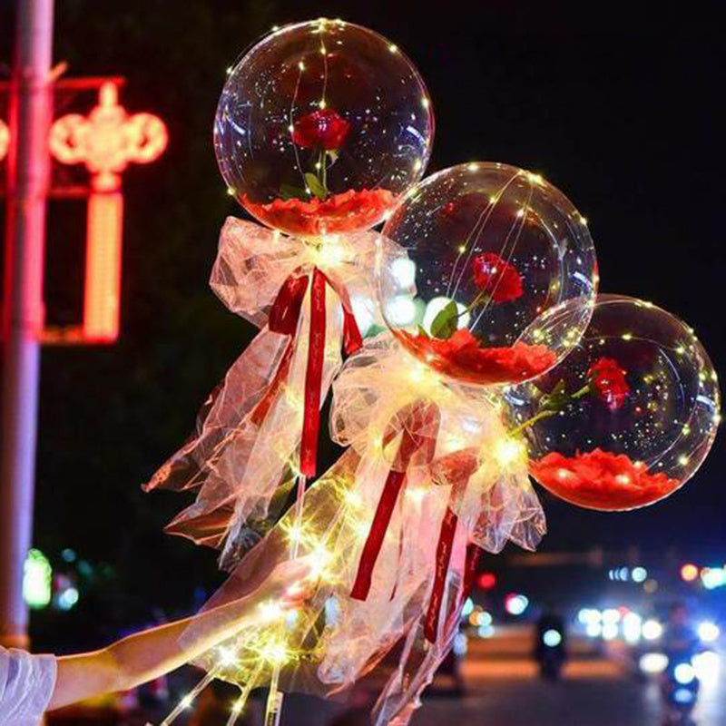 LED rose balloon bouquet with glowing fairy lights and red roses inside clear balloons at night