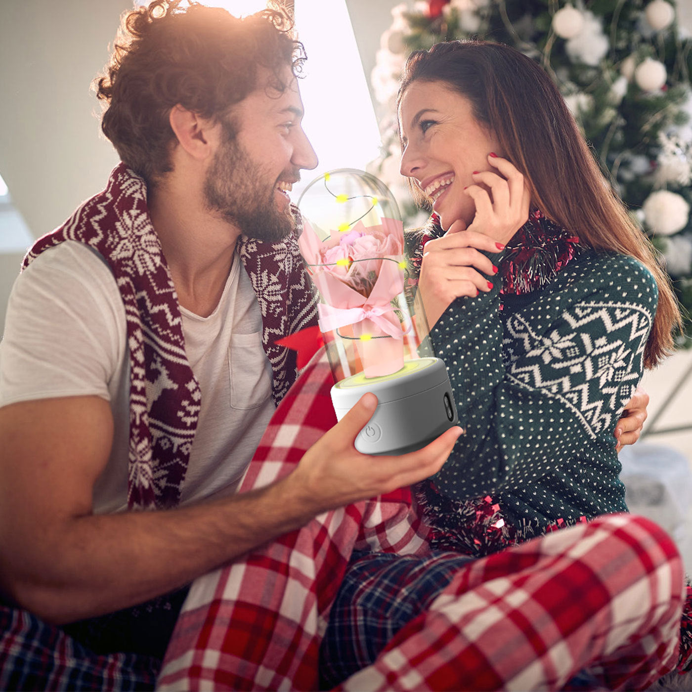 Couple enjoying romantic moment with LED rose night light speaker in a cozy holiday setting