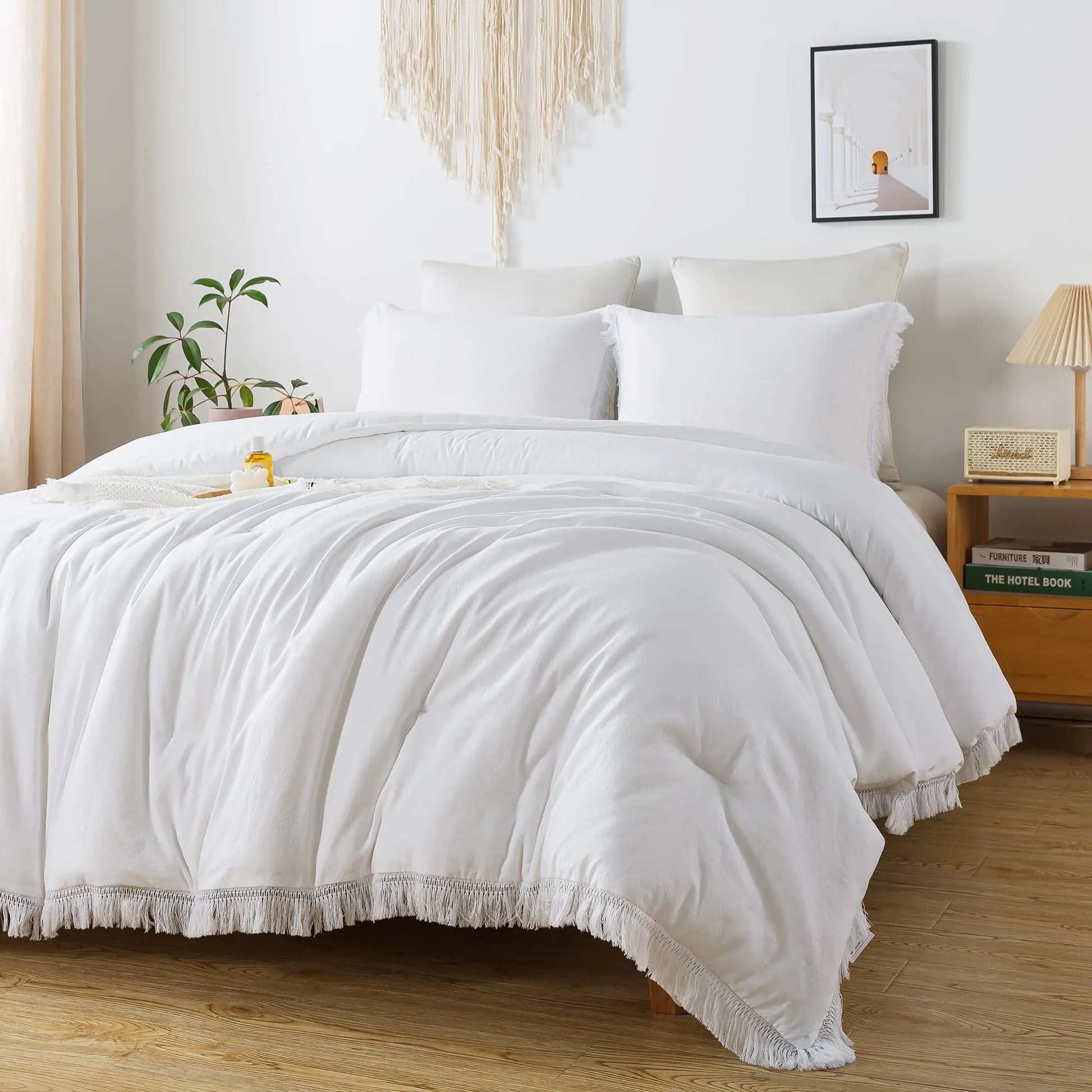 White lightweight all season bed set on a modern wooden bed with pillows and decorative fringe