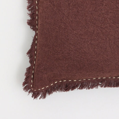 Close-up of brown linen pillow with fringe edges and decorative stitching by Shopi Vella